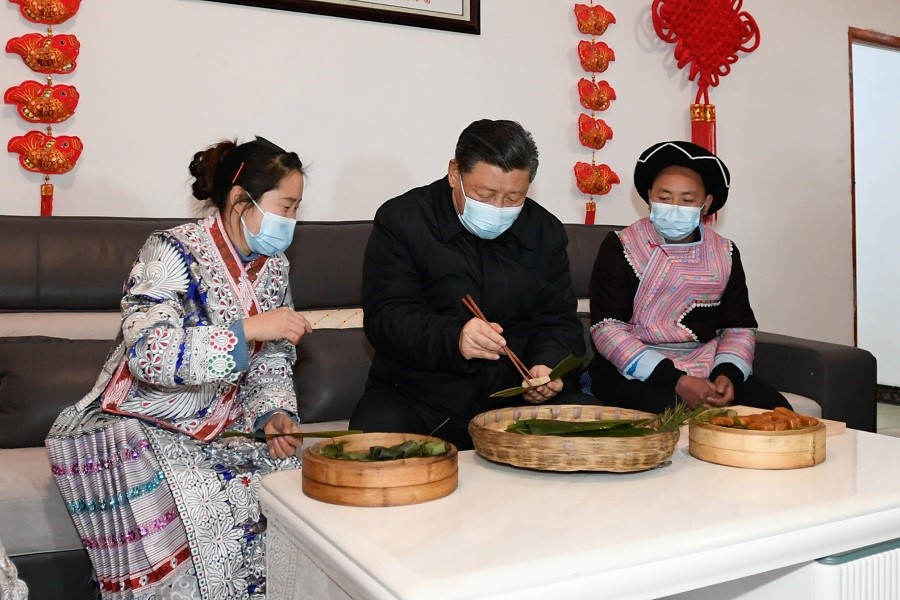 2021年2月3日下午，習(xí)近平在貴州畢節(jié)市黔西縣新仁苗族鄉(xiāng)化屋村苗族村民趙玉學(xué)家，同一家人邊聊家常邊制作當(dāng)?shù)貍鹘y(tǒng)節(jié)日食品黃粑。新華社記者 李學(xué)仁 攝